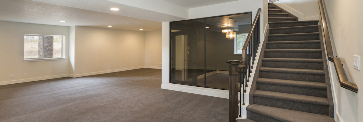 A Finished Basement in Boulder fully carpeted with stairs.