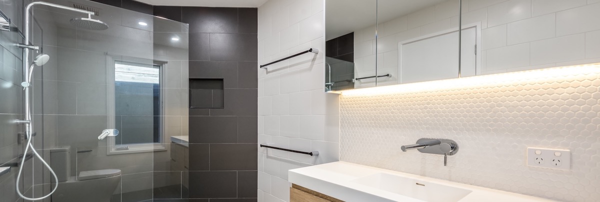 A completed Bathroom Remodel in Broomfield showcasing a black tiled feature wall.